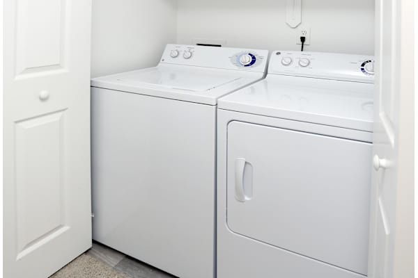 A white washing machine and dryer in a small laundry room.